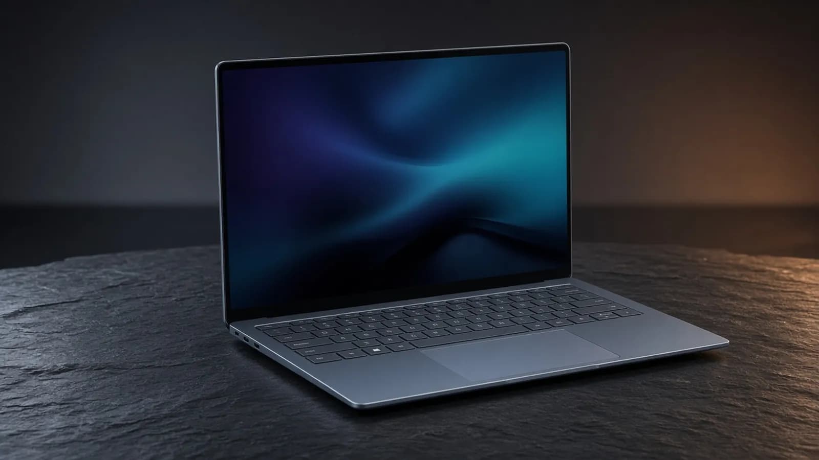 A thin blue-gray aluminum 14-inch laptop open on a dark slate surface, its OLED screen showing an indigo and teal gradient